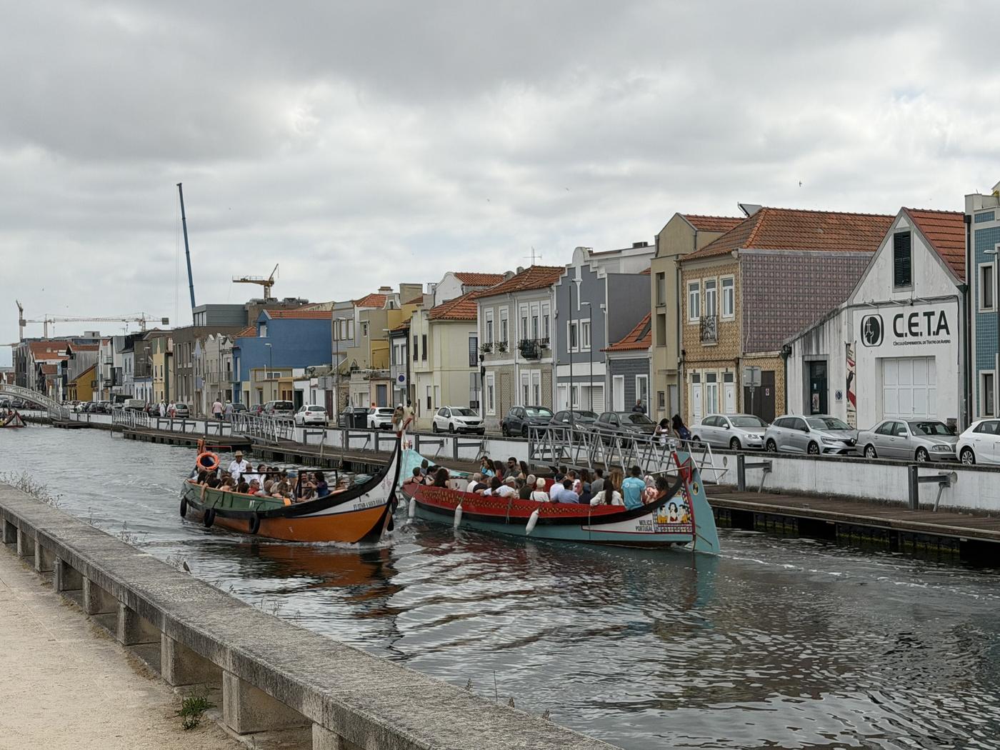 Zwei Moliceiro-Boote auf dem Kanal in Aveiro, bunte Häuser im Hintergrund